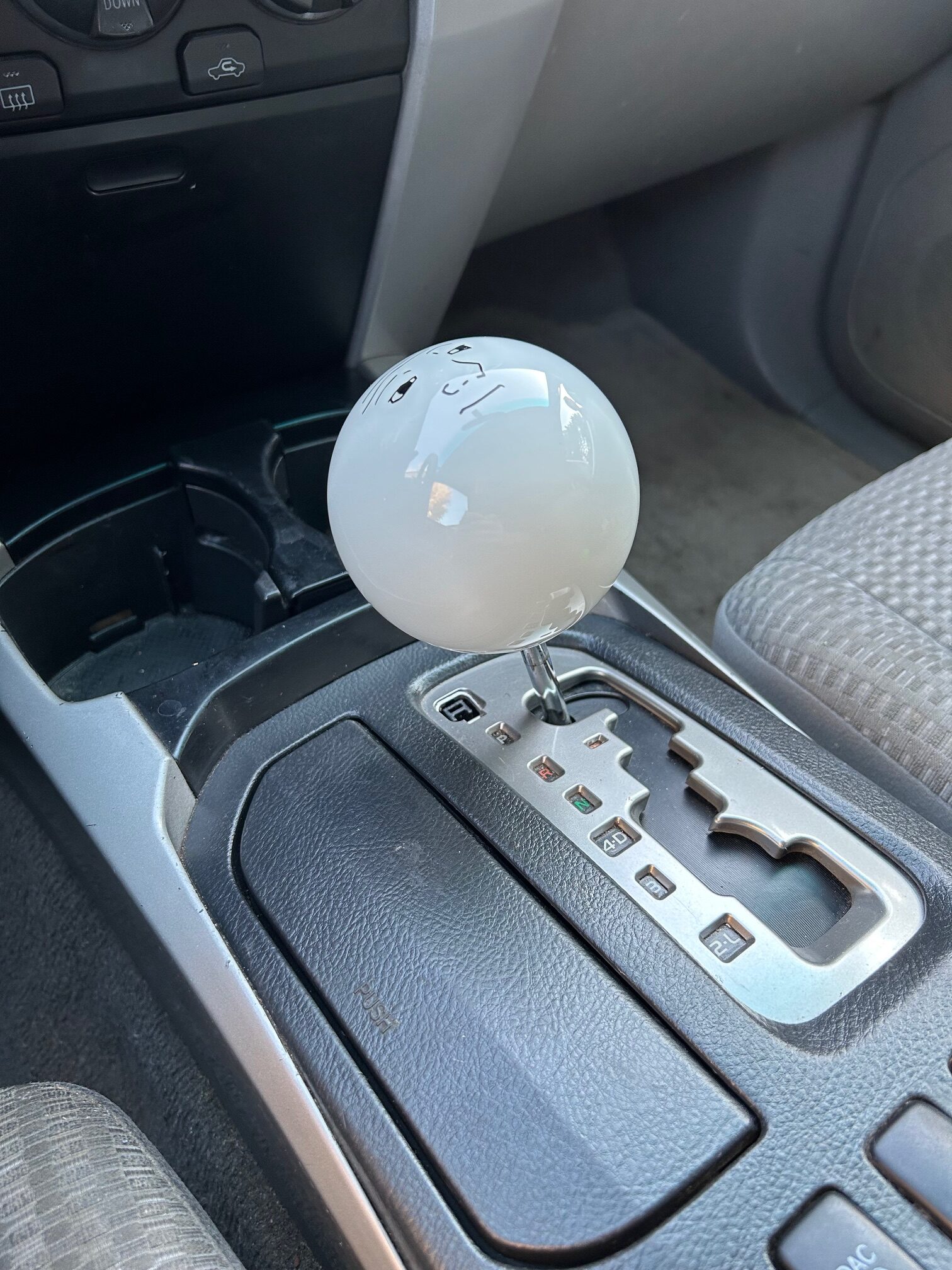 Very large white shift knob installed in a Toyota 4Runner with an automatic transmission.