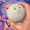 Large shift knob being held by a hand with some wacky AI generated nonsense in the background. There is a face on the shift knob.